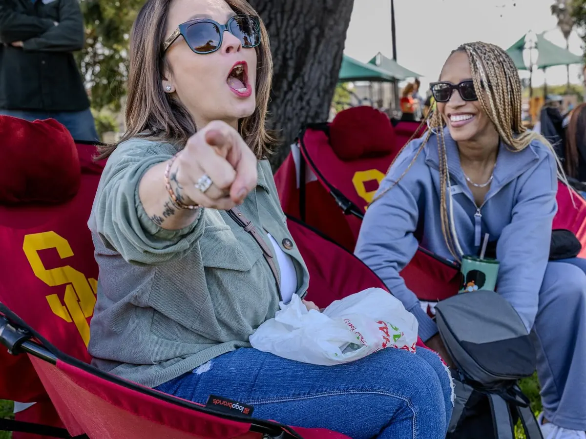 Two women cheering from their camp chairs