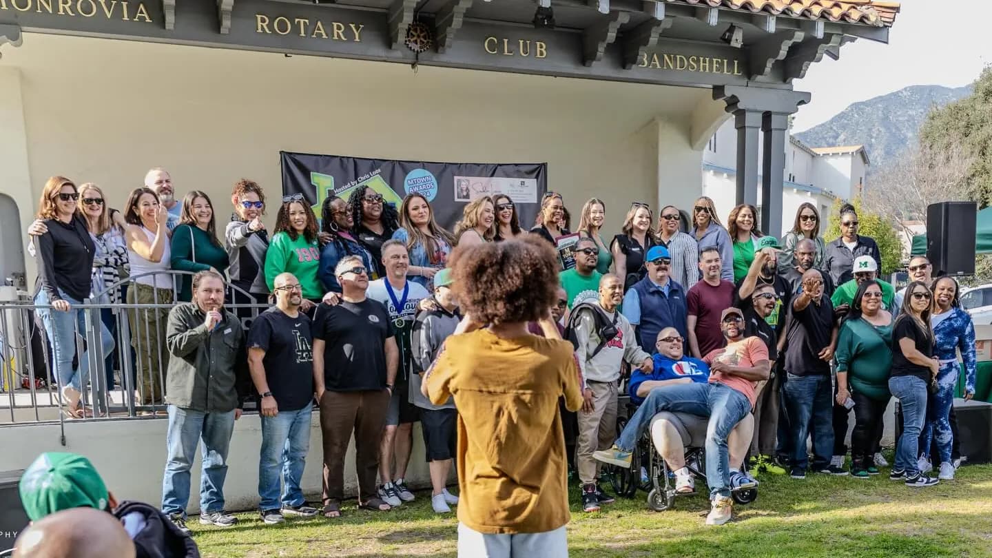 Neighbors gathered for a group photo in front of the Rotary bandshell at Library Park