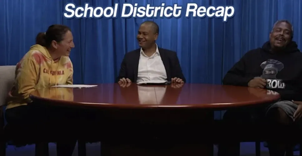 Three hosts laughing at the round table on the KGEM set for the School District Recap